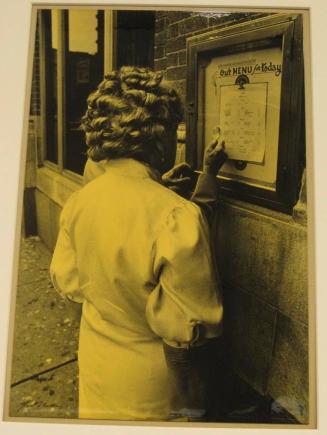 Untitled (two old folks viewing menu with magnifier)