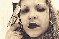 BooBoo points a revolver to her head symbolizing her dedication to La Vida Loca-the crazy life, "Playboys" gang, Los Angeles
