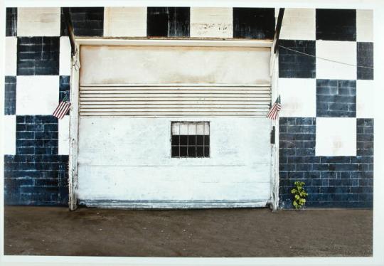 White Overhead Door Surrounded by a Checkerboard Wall