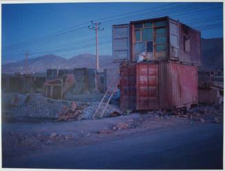 On the very northern edge of Kabul. A shipping container is re-purposed as home to men working in a yard casting concrete blast walls. Each section, when sold to foreign embassies or the military, fetches $1000 per piece.