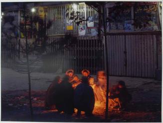 Before dawn, construction workers warm themselves over burning plastic and cardboard before beginning the job of attempting to get hired for a day’s work.