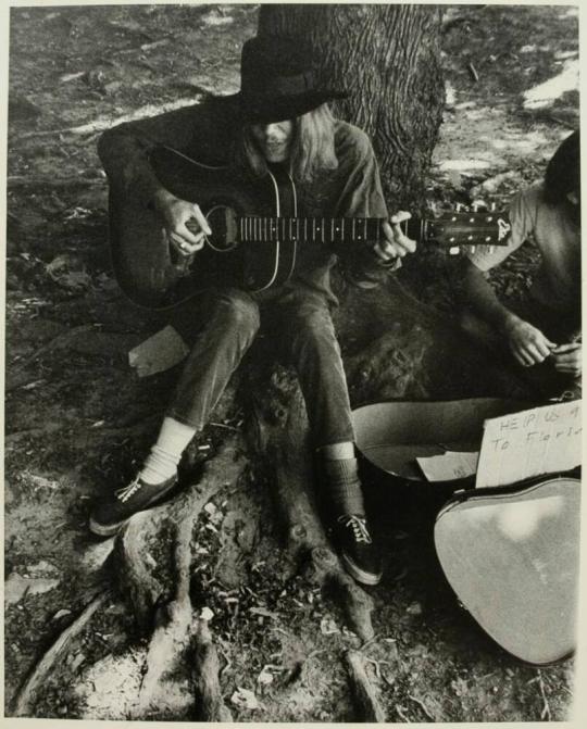 [Man Playing Guitar for Money in Park]