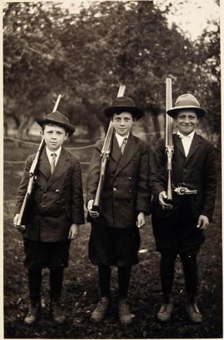 [postcard, three boys in uniform with rifles]