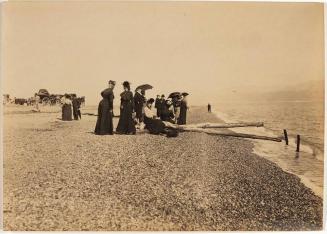 [beach scene with men and women and a wagon in the background]