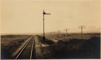 [landscape railroad tracks and signal pole with power lines]