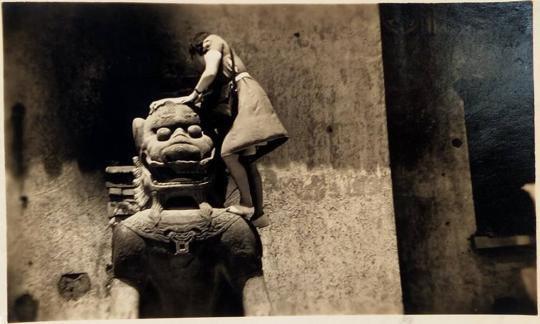 [woman in dress climbing on top of ancient statue]