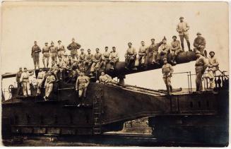 [men in military uniform posing on equipment]