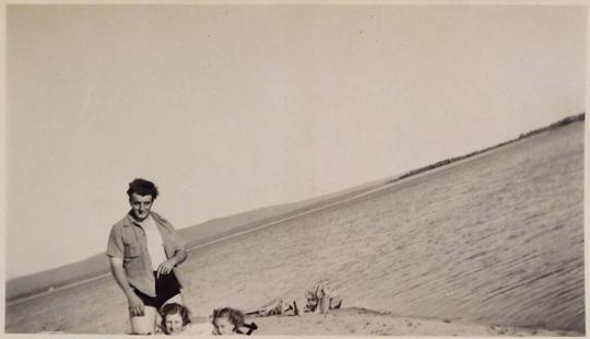 [three people in front of sea]