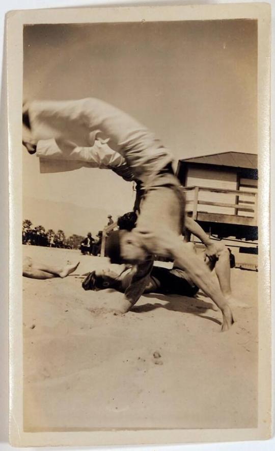 [man doing handstand on beach]