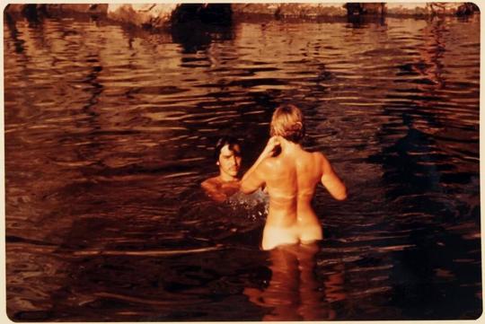 [back of nude woman and man in water]