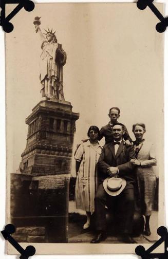 [four people in front of Statue of Liberty]