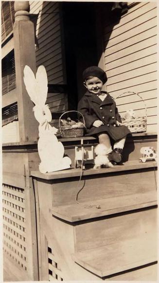 [child on steps in front of house with toys "April 30, 1935 / 2 yrs. 1 month"]