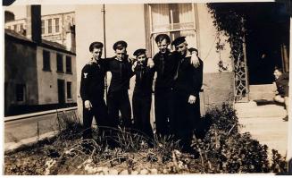 [five men in military uniforms standing with arms around each other in front of house with boy at right on steps "WOODY, B.T. KUHN, CARL GARRETT, / L.B. YTZEN, ROY YOUNG"]