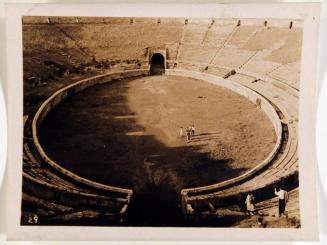 [view from above of coliseum with three people in center]