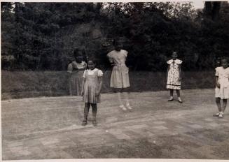 [double exposure of girls in dresses on a lawn in front of trees]