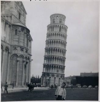 [man standing and leaning in front of the leaning tower of Pisa "Pisa 10/55 (?)'Leaning Tower of Pisa' / she sure leans / (me too) / Italy"]