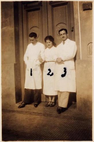 [two men and one woman wearing white coats standing in doorway with numbers 1, 2, and 3 handwritten on each person "28 Agost 1937 / 1 Davide mis socro / 2 Lua sonella / 3 Lo "]