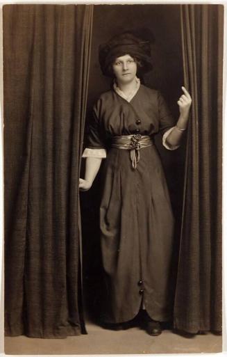 [postcard- woman in costume emerging from curtains]