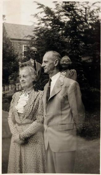 [double exposure of man and woman in front of house]