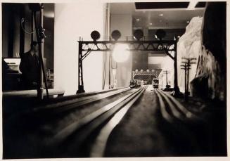 [view from tracks of model train set with man at left]