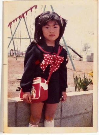 [girl wearing dark blue and red in front of playground]