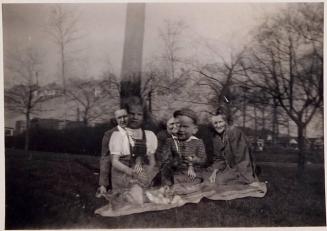 [double exposure with two children and two women sitting on blanket on grass]