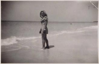 [woman at beach standing with feet in water]