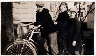 [two boys on bicycle with girl]