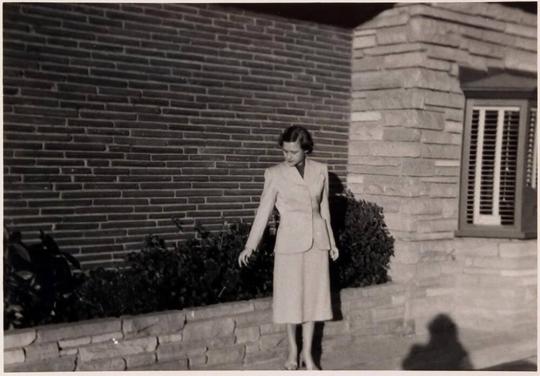 [woman standing in front of building "ME"]