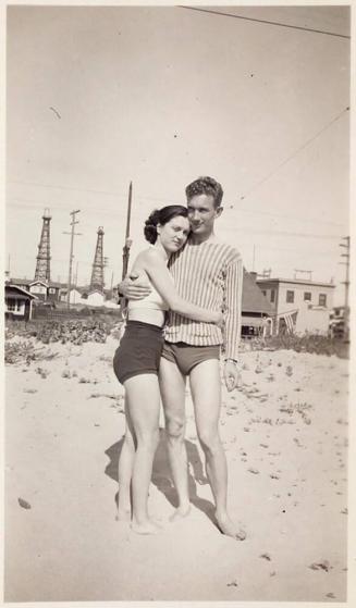 [man and woman embracing on beach]