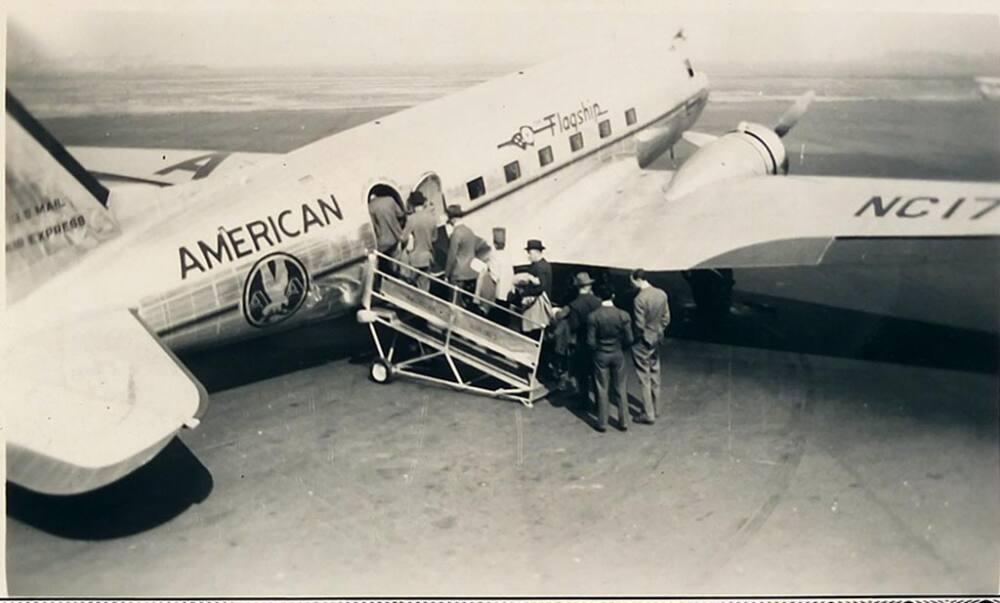 [people boarding American airlines plane on tarmac 