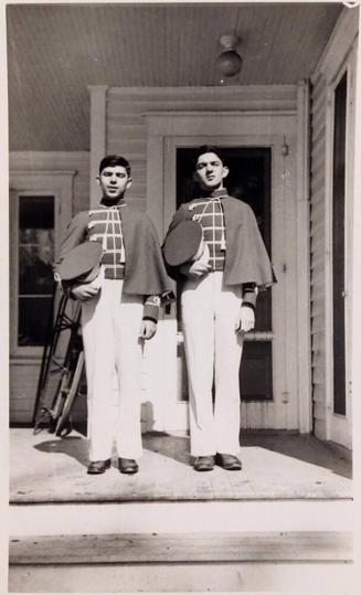 [two young men in uniform standing on porch]