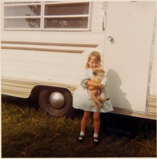 [girl and dog in front of recreational vehicle]