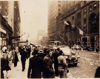 [people on sidewalk with paper floating down "The old homestead - / 100 E 42 / V-E Day / May 8, 1945"