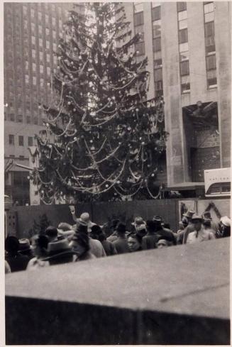[people standing at the Christmas tree in Rockefeller Center in New York]