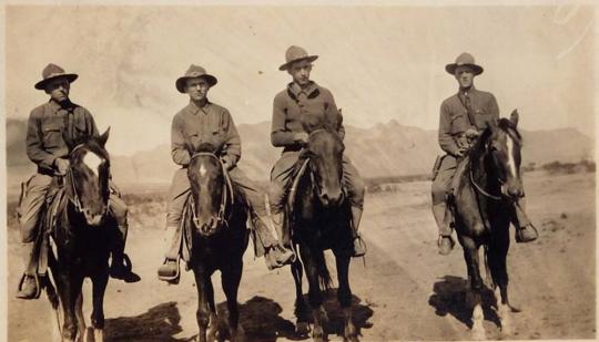 [four men on horses, "Training in Arizona April 12 1917" From Left George Me Ralph Paul]