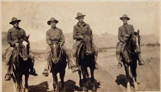[four men on horses, "Training in Arizona April 12 1917" From Left George Me Ralph Paul]