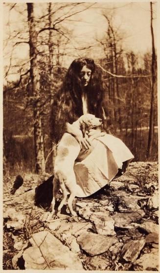 [woman with long hair and dog in wooded area]
