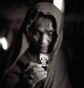 Qurban Gul holding a photograph of her son Mula Awaz, Afghan refugee village, Khairabad, north Pakistan
