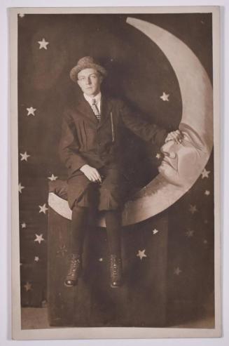 [Man Posing with Large Paper Moon and Stars]