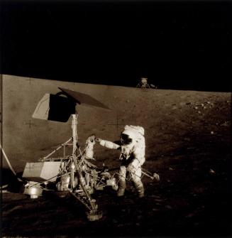 Mission: Apollo-Saturn 12: Charles "Pete" Conrad examining Surveyor 3 space probe which had landed 31 months previously.  The lunar module, Intrepid, is in background.