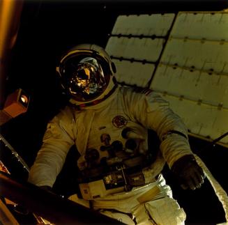 Mission: Skylab 3: Jack R. Lousma with Earth and golden sun shield reflected in visor...