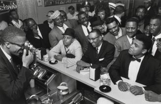 Malcolm X, with Camera, Photographing Cassius Clay in a Miami Drugstore after Clay Won the Heavyweight Championship by Defeating Sonny Liston