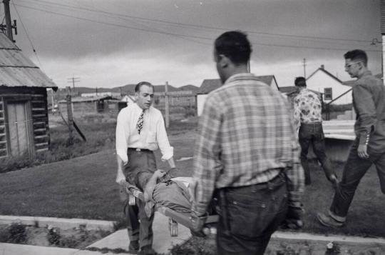 Dr. Ceriani helps carry a patient into the hospital