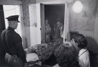At midnight Joe Jesmer's womanfolk stand silently around the door to see him taken away.