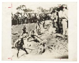 Japanese soldiers bayonetting captured Chinese soldiers in trench; Japanese soldiers watch from rim of trench, Nanking