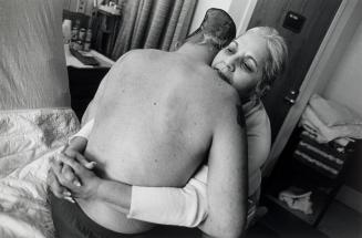 Nelida Bagley helps her son Sgt. José  Pequeño from his bed at the West Roxbury Veterans Medical Center in Massachusetts.