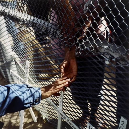 Hands at the Border Fence