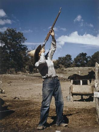 Nell Leathers, homesteader, shooting hawks which have been carrying away her chickens