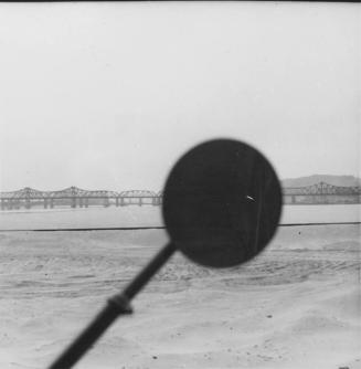 [view of water and bridge from inside car with shadow of side mirror]